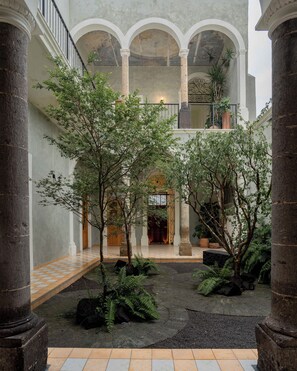 A courtyard with columns, a checkered floor, and potted plants. - Bonito Mini loft Zona Centro SF (Guadalajara)