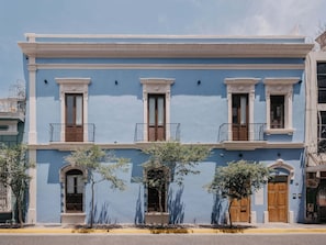 A two-story building with a blue facade, white trim, and a balcony on the second floor. - Alojamiento en casa histórica del centro de GDL LC (Guadalajara)