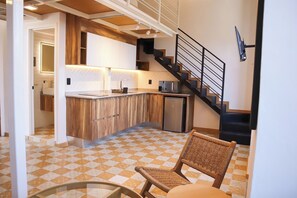 A kitchen with a herringbone tile floor, a wooden island, and a black staircase. - Suite Loft Guadalajara Centro SF (Guadalajara)