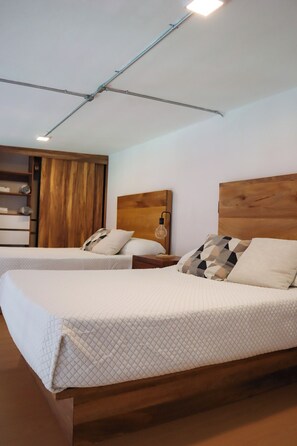 A hotel room with two beds, wooden headboards, a nightstand with a lamp, and a wardrobe. - Suite Loft Guadalajara Centro SF (Guadalajara)