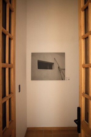 A hallway with a framed picture on the wall, wooden doors, and a tiled floor. - Loft histórico en el corazón de GDL LC (Guadalajara)