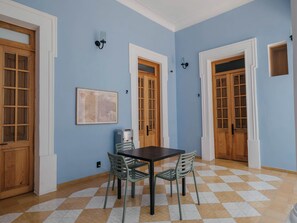 A room with a checkered floor, a table with chairs, and wooden doors. - Loft histórico en el corazón de GDL LC (Guadalajara)