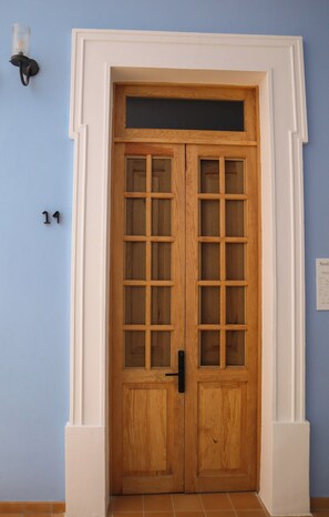A wooden double door with glass panels, a black handle, and a white frame. - Bonito mini loft en el corazón de Guadalajara LC (Guadalajara)