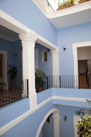 A multi-level interior with blue walls, white trim, and black railings. - Bonito mini loft en el corazón de Guadalajara LC (Guadalajara)