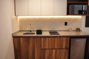 Een keuken met een backsplash van visgraat tegels, een roestvrijstalen koelkast en een inbouwvaatwasser.