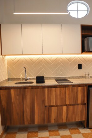 A modern kitchen with a herringbone-patterned backsplash, a built-in sink, and a stainless steel refrigerator. - Amplio loft Casa Histórica en Zona Centro SF (Guadalajara)