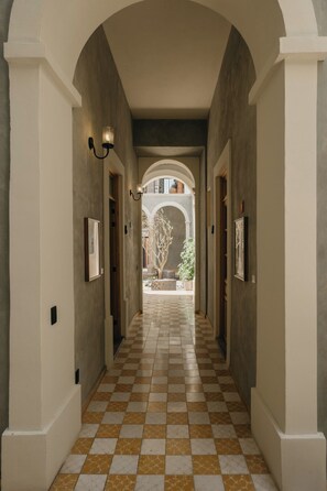 A corridor with checkered flooring, arched doorways, and wall-mounted light fixtures. - Amplio loft Casa Histórica en Zona Centro SF (Guadalajara)