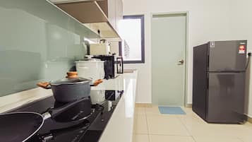 Een keuken met een fornuis, een koelkast en een magnetron.