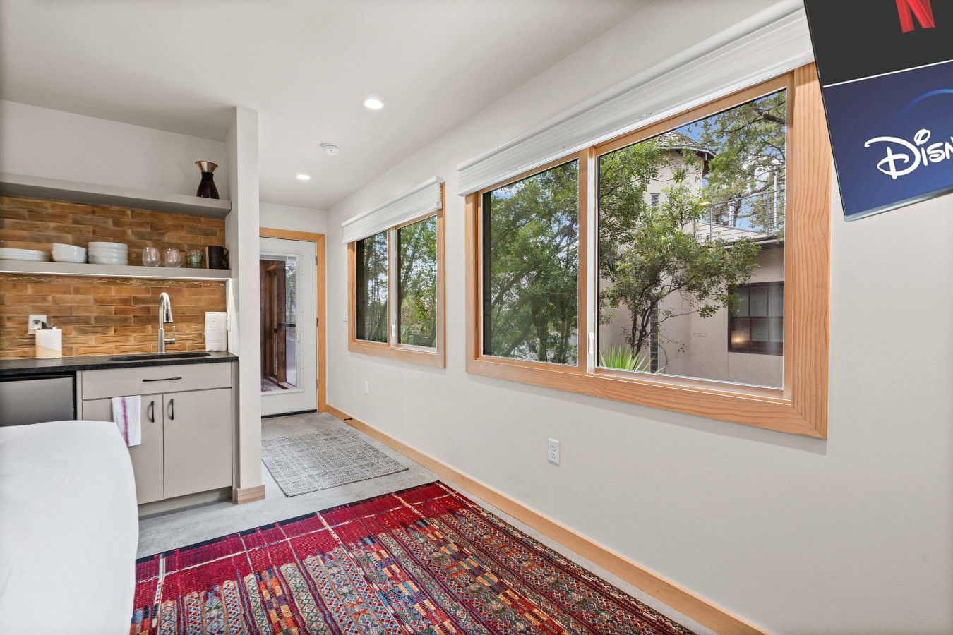 A modern kitchen with a wooden backsplash, a sink, and a window.