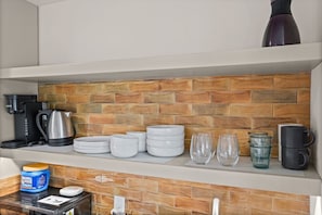 Open shelving keeps dishware, glassware and mugs neatly displayed and ready for your stay.