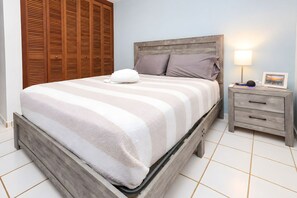 Una camera da letto con un letto, un comodino, una lampada e un armadio in legno.