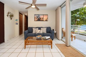 Ein Wohnzimmer mit einer Couch, einem Couchtisch und einem Deckenventilator.