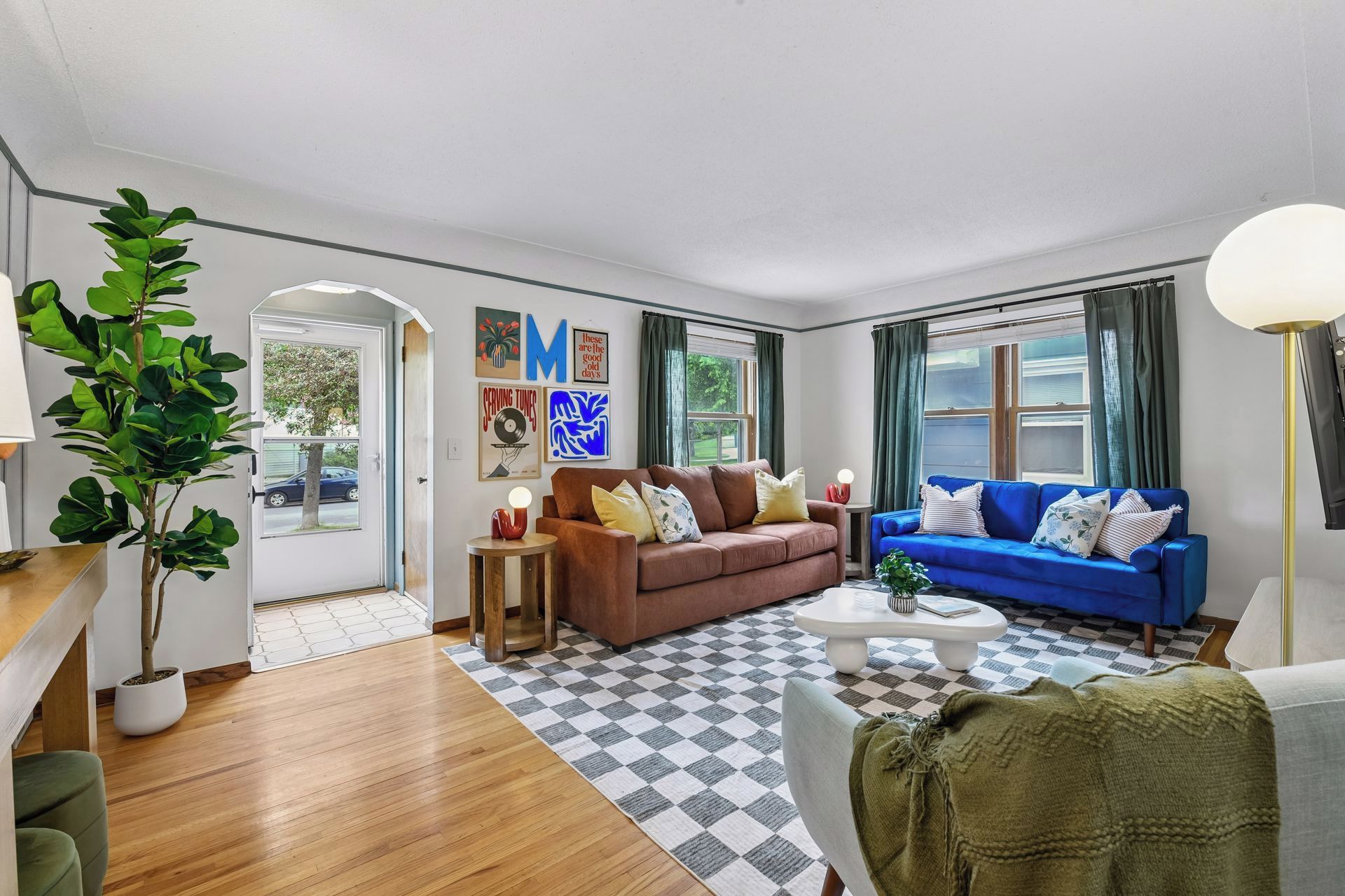 A living room with a brown sofa, a blue sofa, a coffee table, and a lamp.