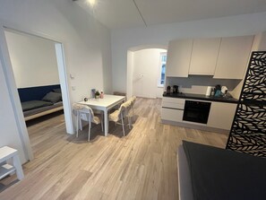 A compact kitchen with a dining area, a small seating area, and a kitchenette. - Top 1 - 2 Minutes to imperial Park, close to center, good public transportation (Wien)
