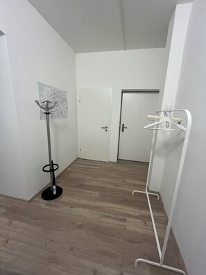 A hallway with a coat rack, a map on the wall, and a door at the end. - Top 1 - 2 Minutes to imperial Park, close to center, good public transportation (Wien)