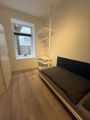 A bedroom with a bed, a window, a built-in wardrobe, and a bedside table. - Top 1 - 2 Minutes to imperial Park, close to center, good public transportation (Wien)