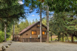 A cabin with a sloped roof, wooden deck, and a fenced area. - Cabin on Yakima River, Fish, Float, Golf, AC, BBQ (Cle Elum)