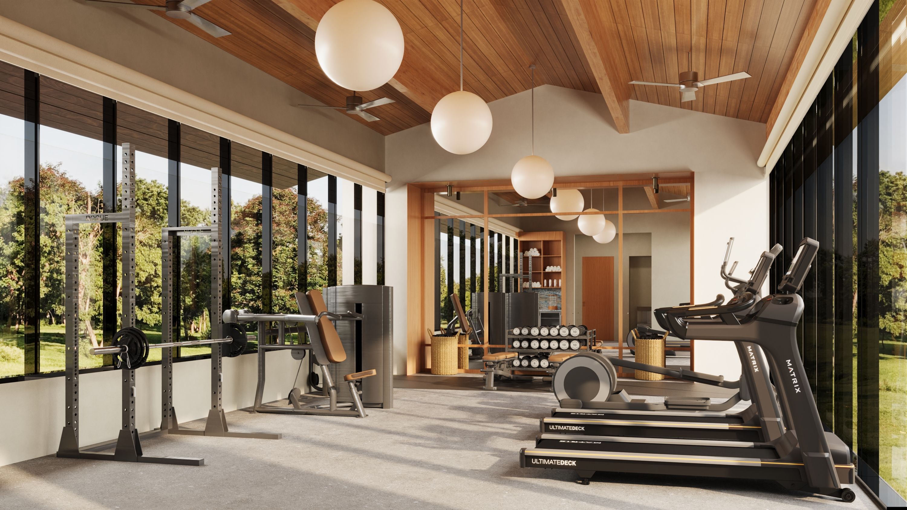 A modern gym with exercise equipment, large windows, and a view of the outdoors.