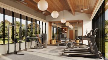 A modern gym with exercise equipment, large windows, and a view of the outdoors.