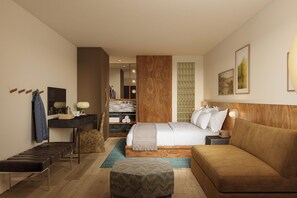 Una habitación de hotel moderna con cama, sofá, escritorio y baño.
