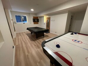 A room with a pool table, a dartboard, and a window with a view of the outside. - Create unforgettable memories in a home designed for comfort, and adventure. (Vernon)