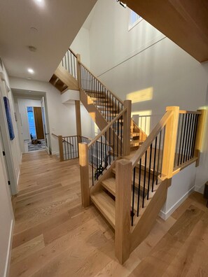 A wooden staircase with a railing, leading to an upper floor. - Create unforgettable memories in a home designed for comfort, and adventure. (Vernon)