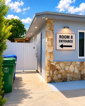 A building with a sign indicating 'ROOM 8 ENTRANCE' with an arrow pointing to the left. - Peaceful 1-bedroom studio with AC, pool front and free parking, in vibrant Miami (Miami)