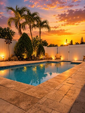 A swimming pool with a sunset view, surrounded by palm trees and a white fence. - Peaceful 1-bedroom studio with AC, pool front and free parking, in vibrant Miami (Miami)