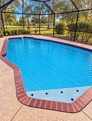 A rectangular swimming pool with a tiled edge, surrounded by a brick border and a metal fence. - Perfect Conroe 4BR Retreat Private Pool  9 Beds (Conroe)