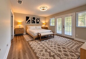 Un dormitorio con cama, lámparas de noche, un tapete y una lámpara de techo.