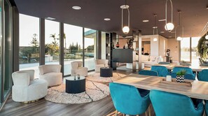 Un interior moderno con comedor, sofás y televisor.