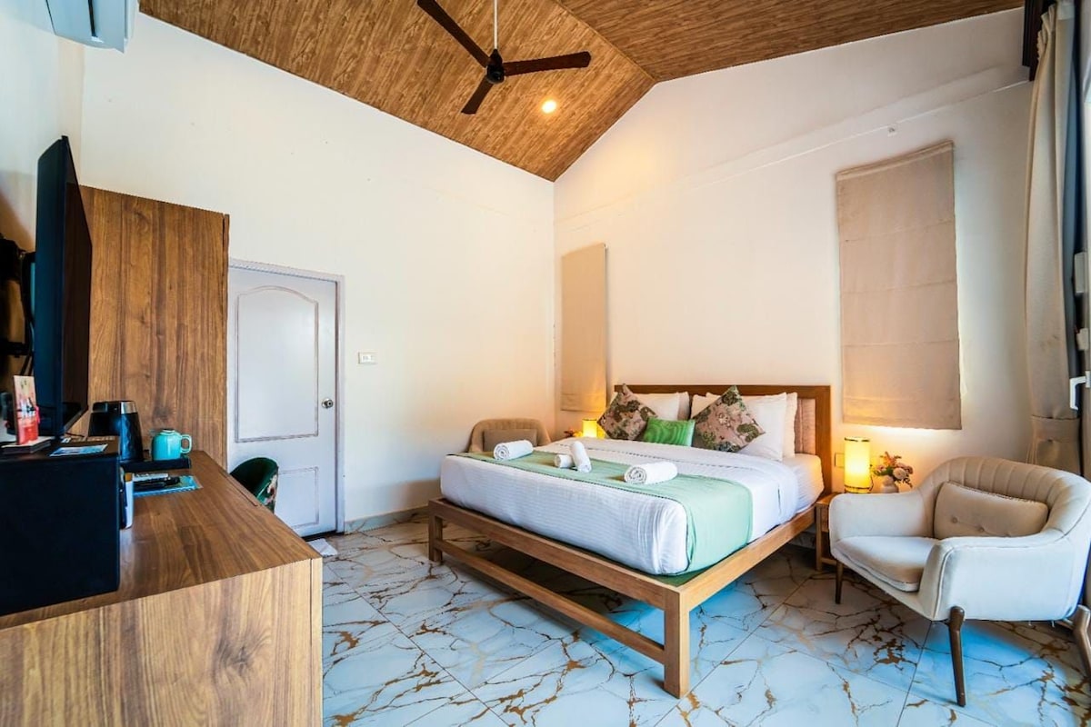 Une chambre à coucher avec un lit, un bureau, une chaise, un ventilateur de plafond et une fenêtre.