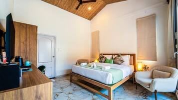 A bedroom with a bed, a desk, a chair, a ceiling fan, and a window.