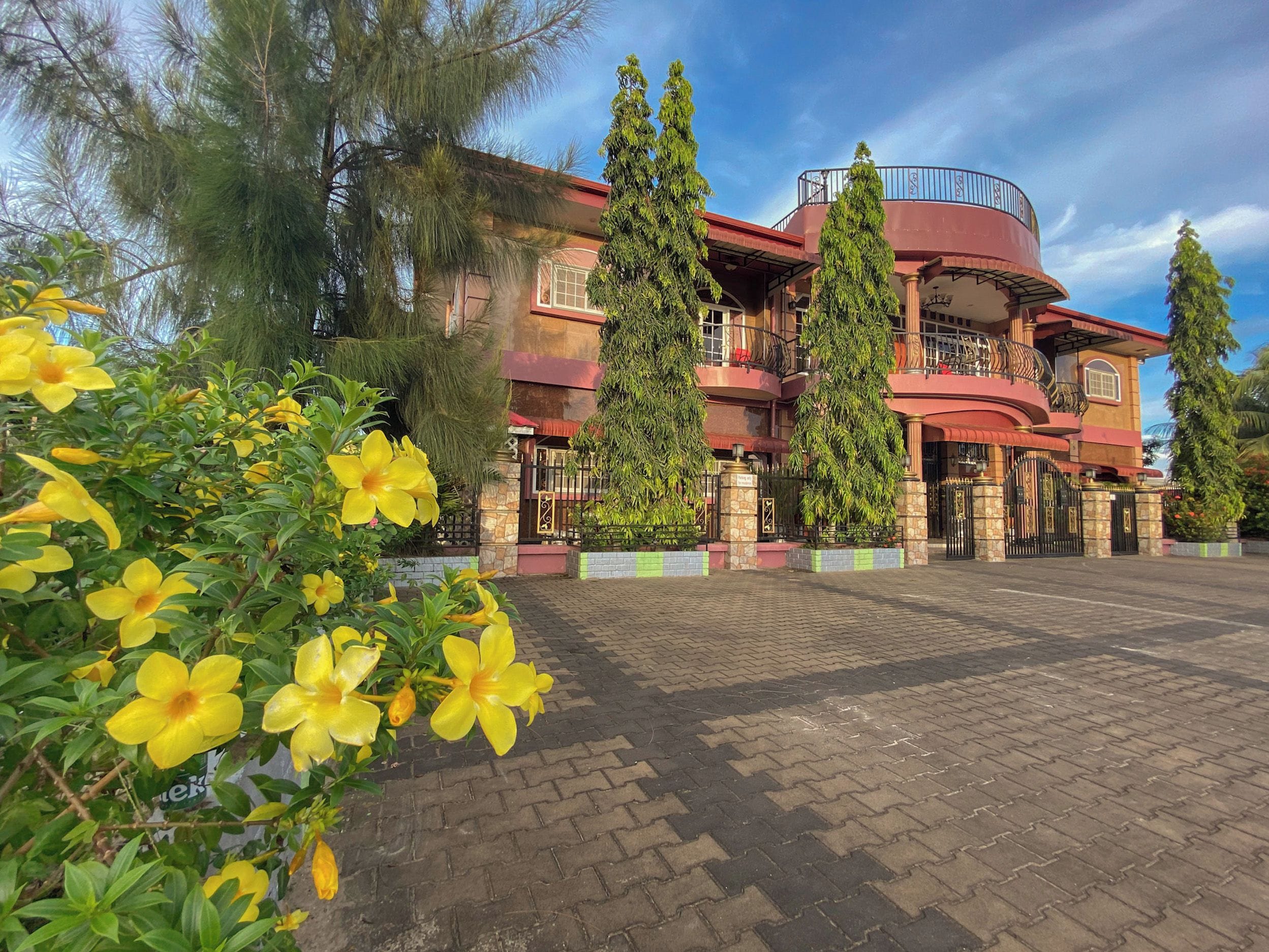 A large, multi-story building with a curved balcony and a gated entrance.