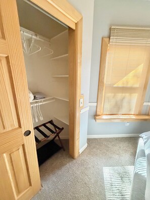 A room with a wooden door leading to a closet with hanging space and a shoe rack. - Family Getaway with pool & Gym (Chico)