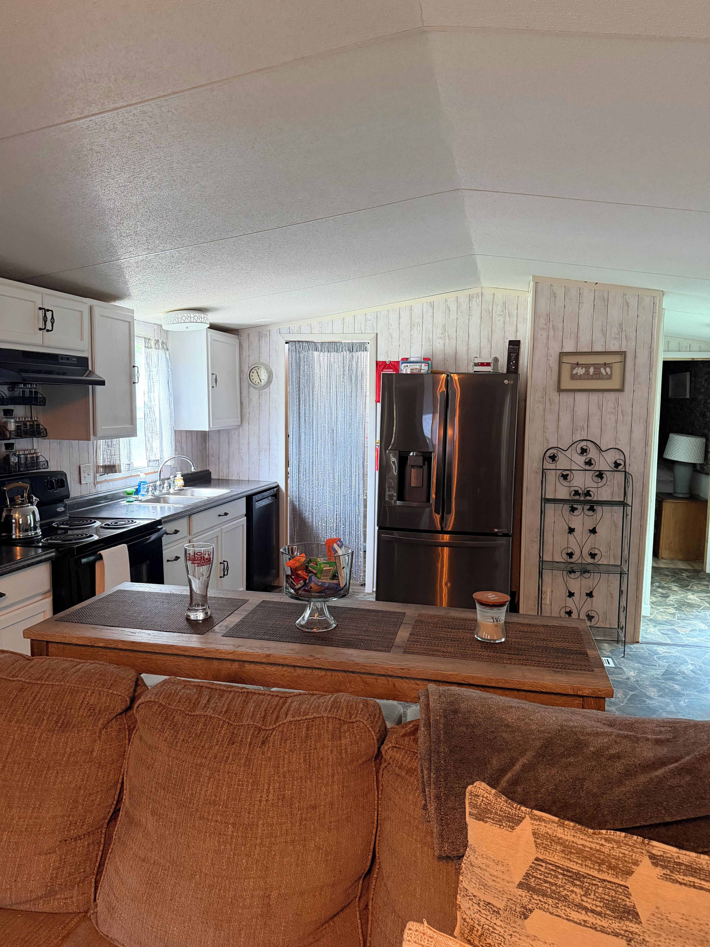 A compact kitchen with a refrigerator, stove, and cabinets.