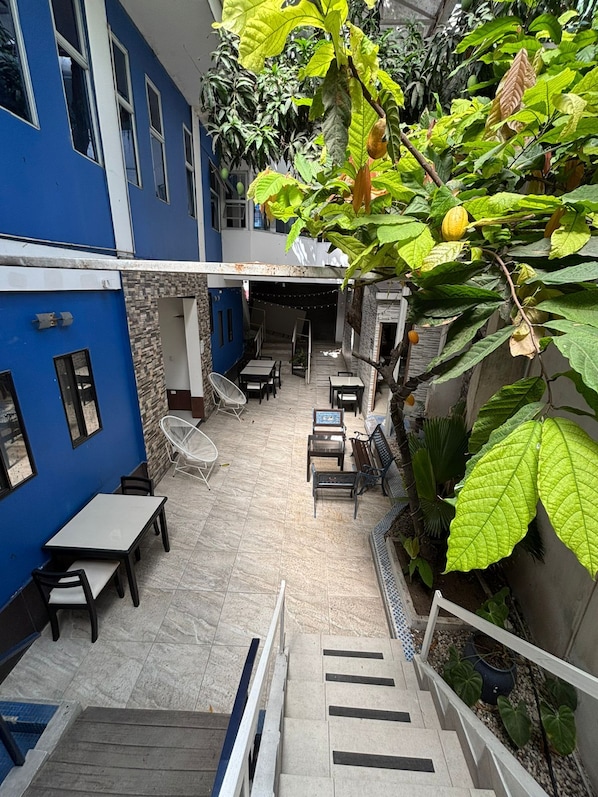 An outdoor patio area with multiple seating arrangements, a staircase, and a variety of plants.