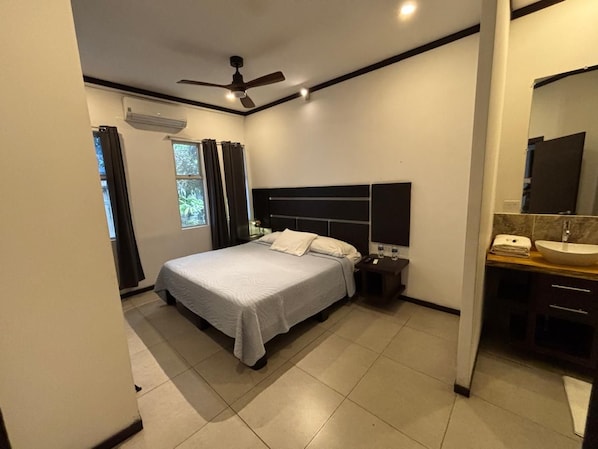 A modern bedroom with a bed, bedside table, and a built-in vanity with a mirror.