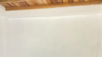 Une chambre avec deux lits, l’un doté d’une tête de lit en bois et l’autre d’une tête de lit simple, les deux étant équipés de draps blancs.
