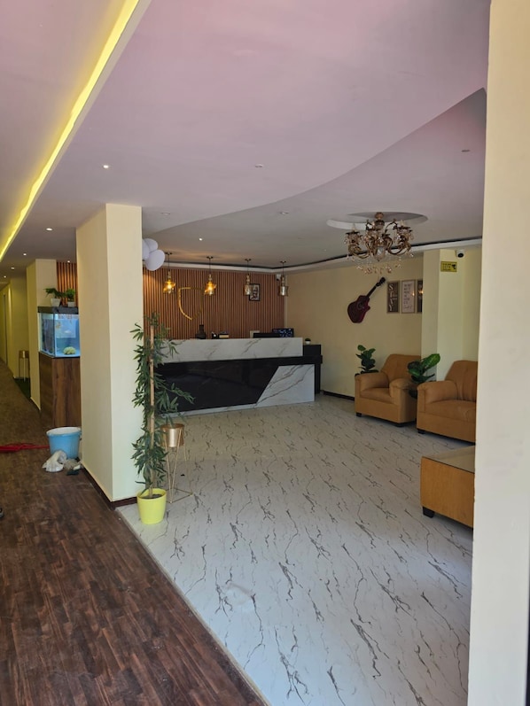 A modern living room with a marble floor, a reception desk, and two sofas. - Hotel East Park Rio (Anekal)