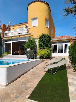 A residential property with a swimming pool, a covered patio, and a well-maintained lawn. - Villa San Antonio with a private pool (Peníscola)