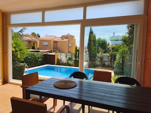 A patio with a pool, outdoor furniture, and a view of neighboring buildings. - Villa San Antonio with a private pool (Peníscola)