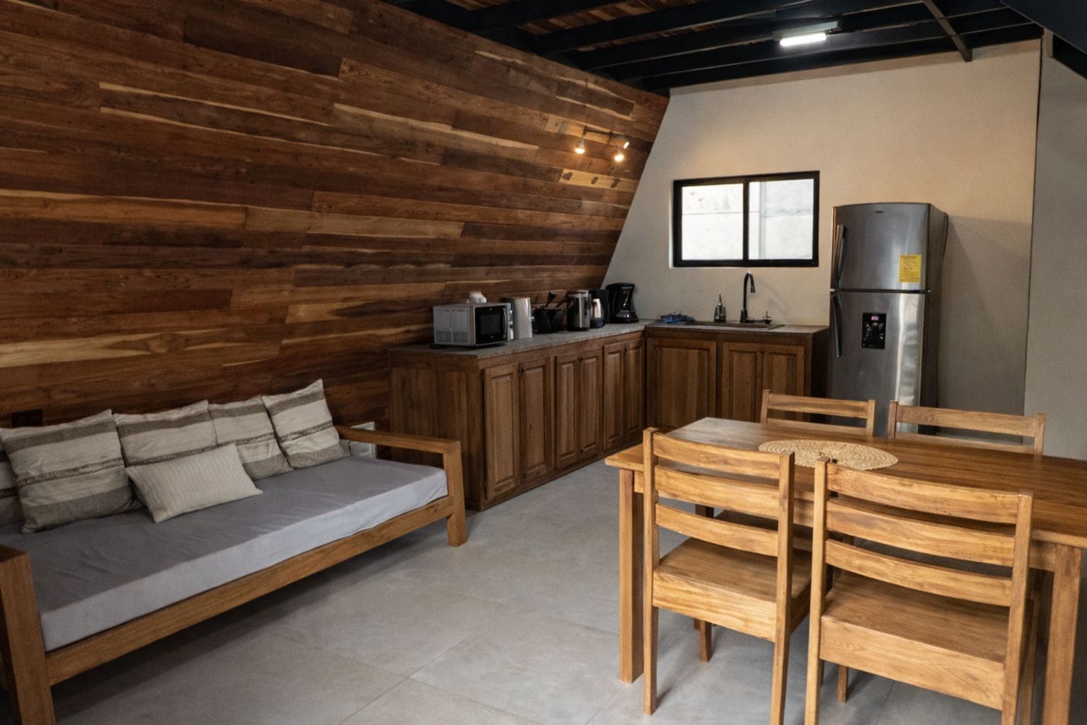 A cozy kitchen with wooden cabinets, a dining table, and a sofa.