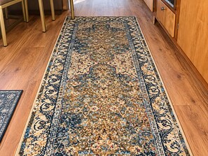 A hallway with a patterned rug, wooden flooring, and a cabinet. - Romantic Vintage Airstream Safari Near Puget Sound (Des Moines)