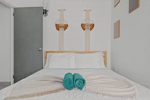 Habitación de hotel con una cama, dos lámparas de pared y una puerta.