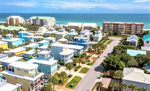 A coastal residential area with colorful houses, a road, and a view of the ocean. - Sunkissed! Oceanview! Pool! Golf Cart! 6 Bedrooms (Destin)