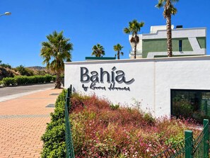 Schild für 'Bahia by Knapp Homes' mit blauem Himmel und Palmen im Hintergrund.