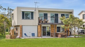 A two-story house with a garage, a balcony, and a patio area. - Shoreline Shack - Escape to the peaceful North Shore of Port Macquarie (North Shore)