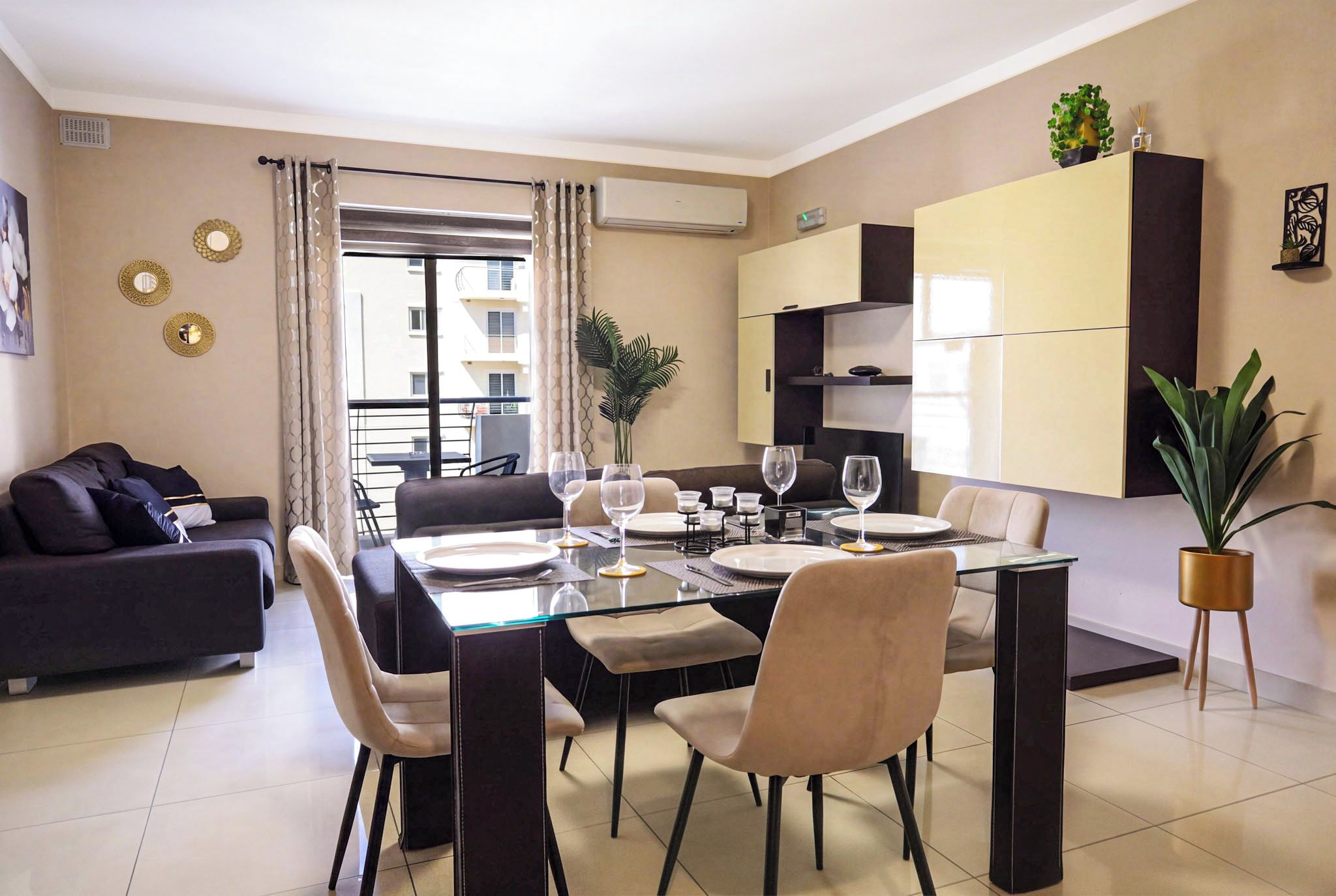 Un espace repas moderne avec une table en verre, plusieurs chaises et un canapé.