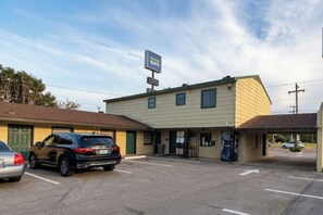 A parking lot with a building that has a sign reading 'Candle Quick'.